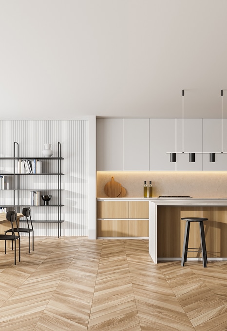 Cuisine minimaliste et moderne avec îlot central en bois clair. Cuisine ouverte minimaliste avec îlot central, meubles bois clair et gris. Étagère noire près des lattes blanches. Parquet chevron.
